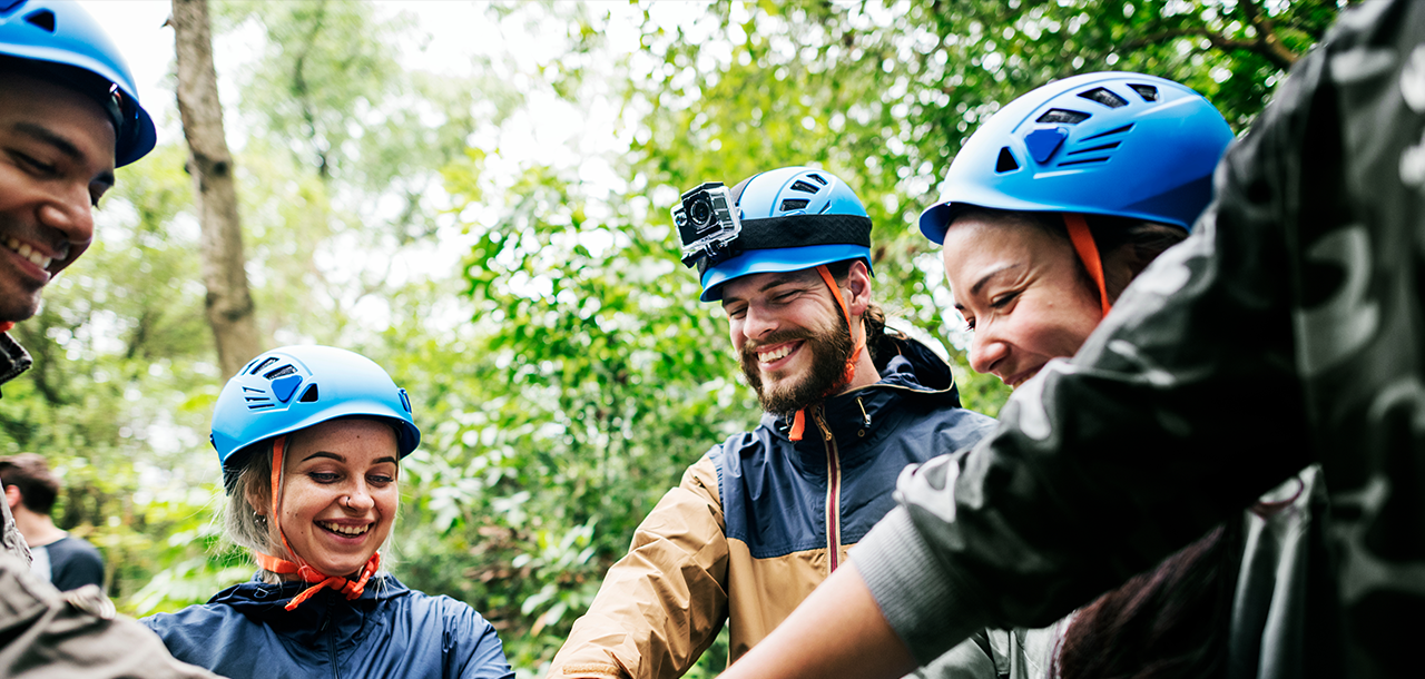 Team members putting their hands together in a circle during a zipline team bonding adventure