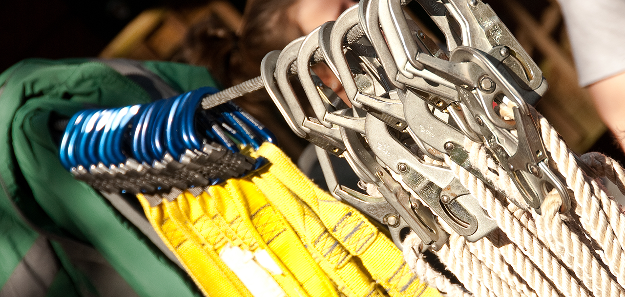 Colorful carabiners and climbing equipment hanging on a rack